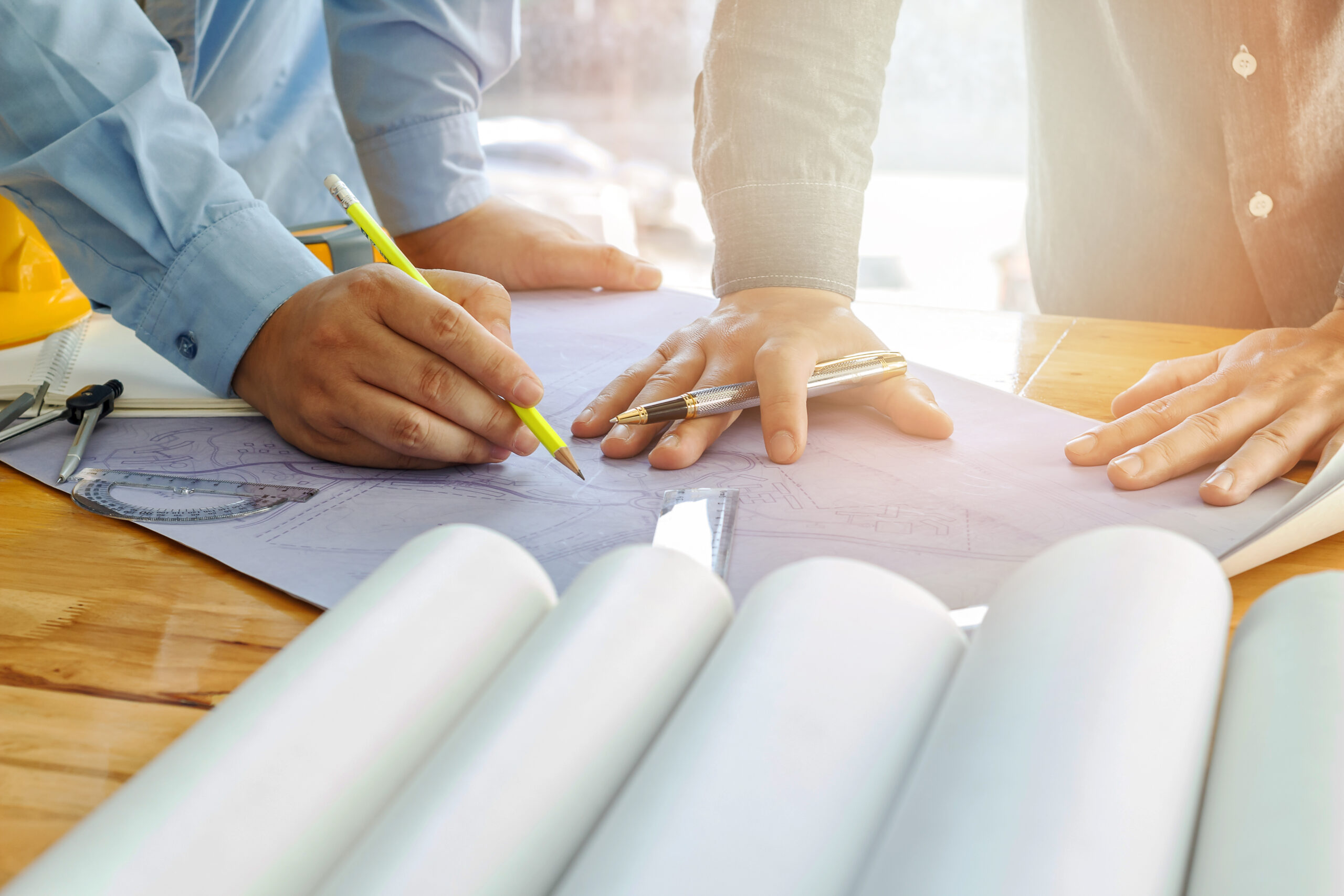 Architect, engineer and foreman discuss with blueprint in office